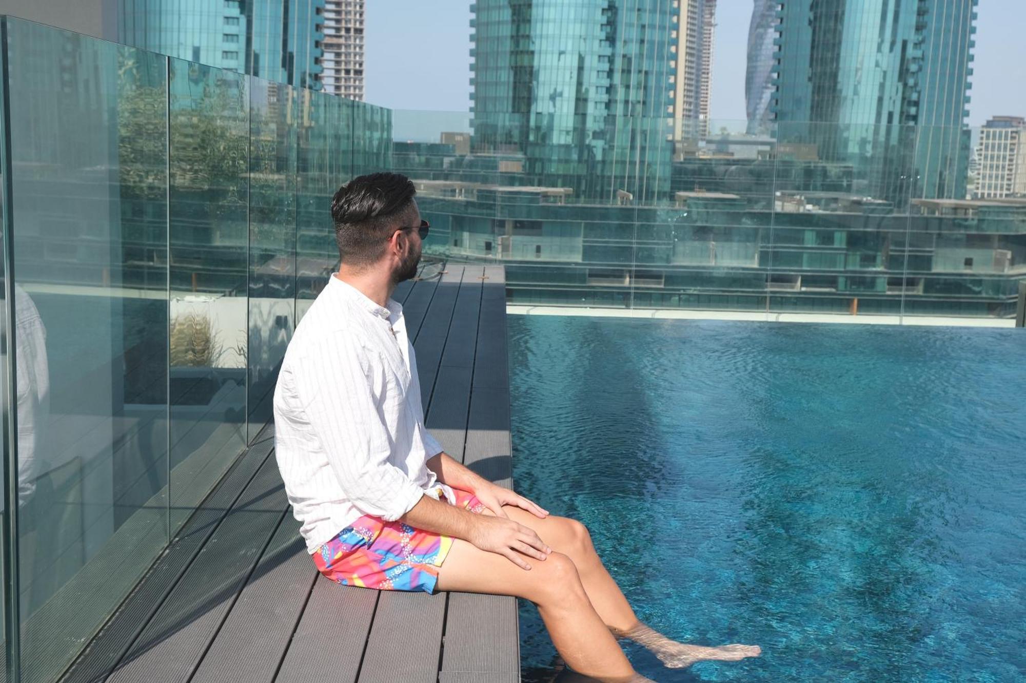 Charthouse Bahrain Hotel Al-Manamah Bagian luar foto A man sitting on the edge of a pool